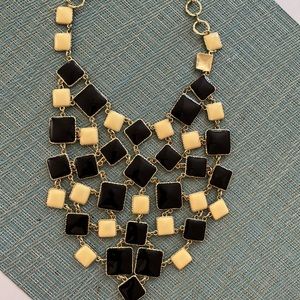 Extravagant choker with dangling black and cream cubes with goldstone chain